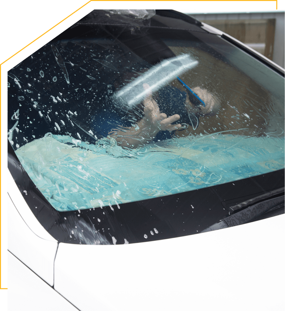 Person cleaning car windshield with squeegee