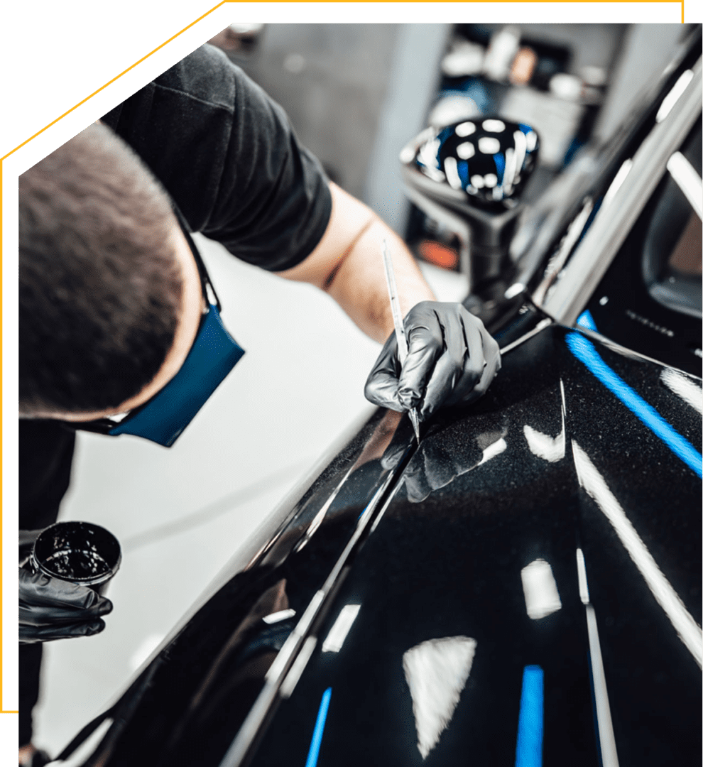 Technician applying paint on car surface