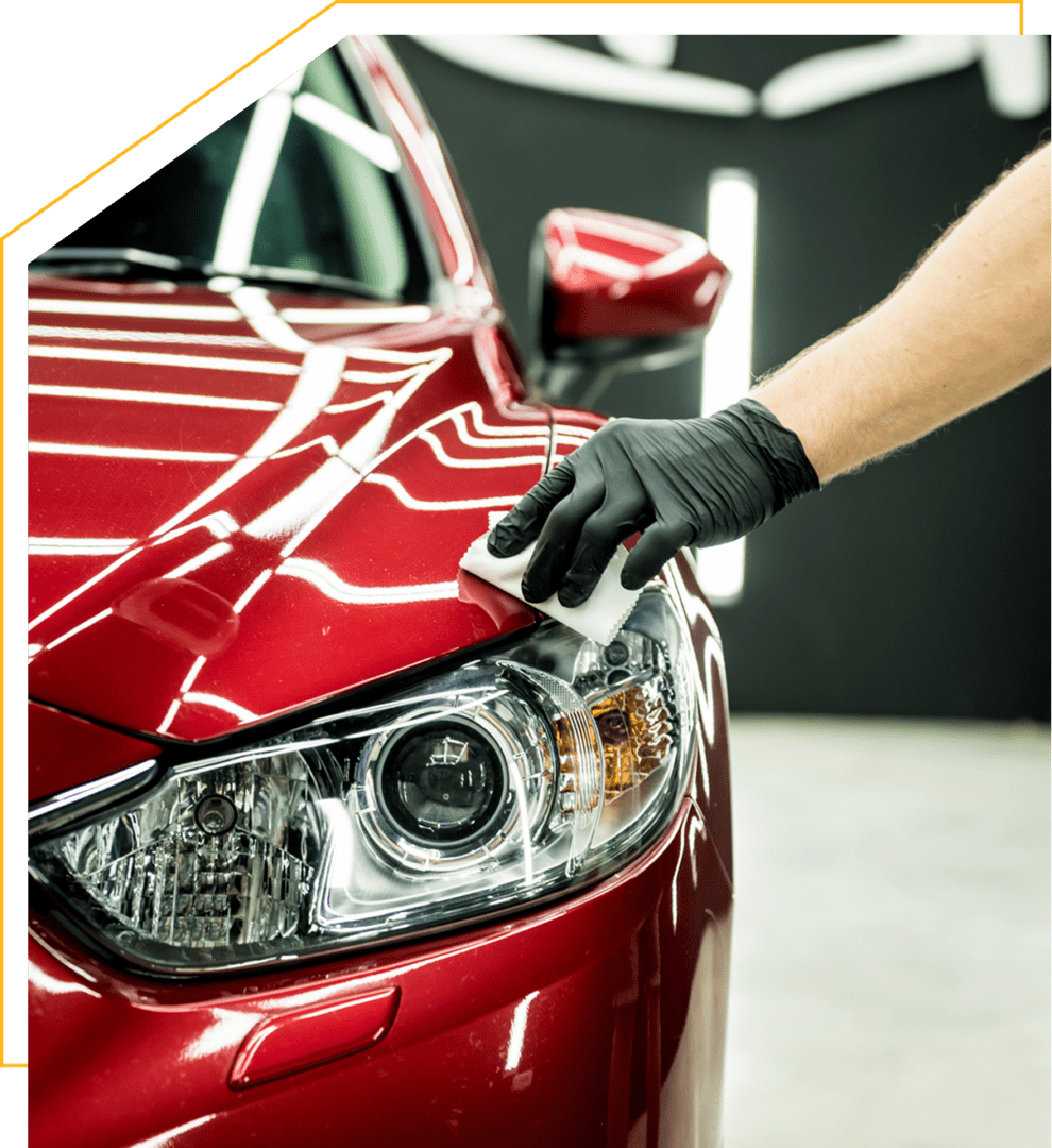 Hand polishing red car's headlight