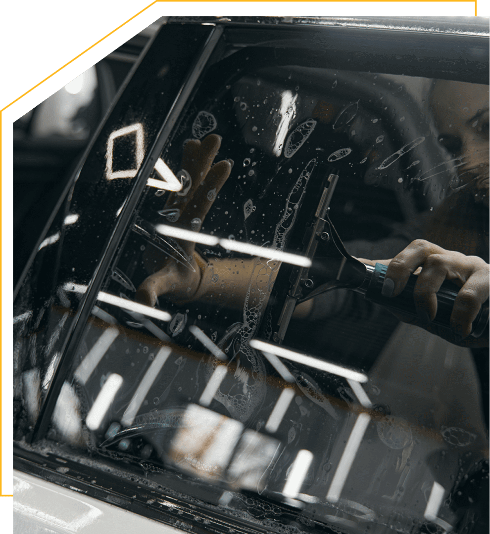 Car window being cleaned with squeegee